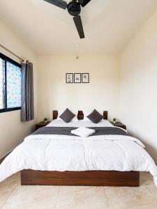 a bedroom with a large bed with a ceiling fan at Hotel Tiger Paradise in Mahirāvani