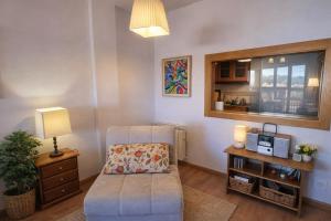a living room with a chair and a table at Apto Marita – Nueva de Llanes cerca de la Playa in Nueva de Llanes
