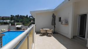 a balcony with a pool and a table and chairs at Le Ranch Hôtel San-Pedro in San-Pédro +17 photos