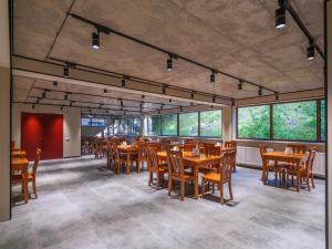 a dining room with tables and chairs and windows at Hotel Iveria in Abastumani