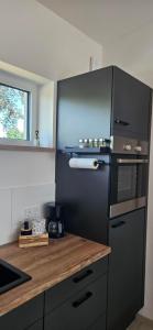 a kitchen with a black refrigerator and a wooden counter at Gartenbungalow Rhönwald in Hilders
