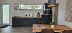 a kitchen with a table and a sink and a counter at Gartenbungalow Rhönwald in Hilders