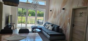 a living room with a couch and a table at Gartenbungalow Rhönwald in Hilders