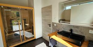 a bathroom with a black sink and a shower at Gartenbungalow Rhönwald in Hilders