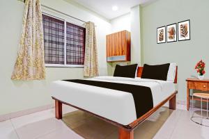 a bedroom with a bed and a desk and a window at Super Hotel O Dighori Nagpur in Sakardarā +25 photos