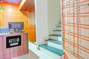 a lobby of a hotel with stairs and a television at Super Hotel O Dighori Nagpur in Sakardarā