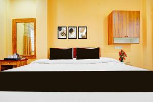 a bedroom with a large bed and a mirror at Super Hotel O Dighori Nagpur in Sakardarā