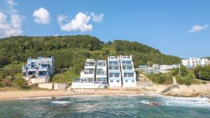 a group of buildings on a beach next to the ocean at yeongdeok chaeumneul poolvilla in Yŏngdŏk