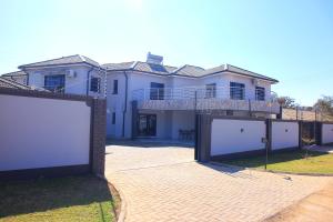 a large white house with a large garage at Brooke Paradise in Bulawayo