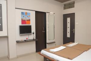 a hospital room with a bed and a tv at Hotel Royal Residency Executive in Miraj +26 photos