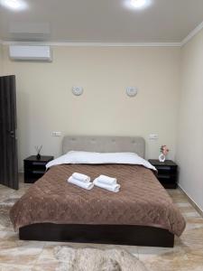 una camera da letto con un letto su cui sono appoggiati due asciugamani di Hotel Sofiyvka Park a Umanʼ