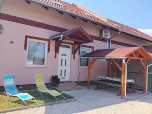 two chairs and a picnic table outside of a house at Kötél utcai vendégház in Balatonkeresztúr