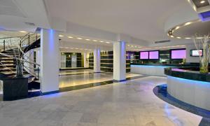 a lobby with a staircase in a building at SOL by Meliá Milanos Pingüinos in Son Bou