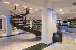 a lobby with a spiral staircase in a building at SOL by Meliá Milanos Pingüinos in Son Bou