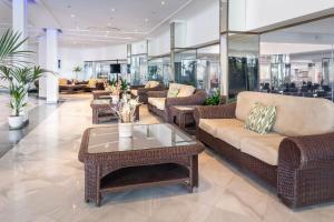 a lobby with couches and tables in a building at SOL by Meliá Milanos Pingüinos in Son Bou +43 photos