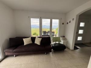 a living room with a couch and a large window at Apartment Luxenweid by Interhome in Reichenburg