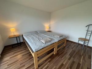 a bed in a room with two tables and a chair at Apartment Luxenweid by Interhome in Reichenburg
