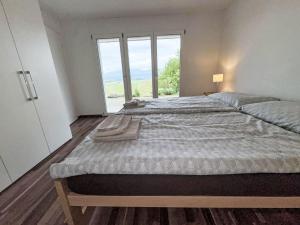 a bedroom with a large bed with a large window at Apartment Luxenweid by Interhome in Reichenburg +14 photos