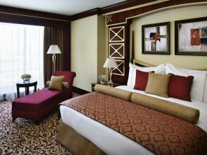 a hotel room with two beds and a chair at Mövenpick Hotel City Star Jeddah in Jeddah