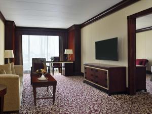 a hotel room with a television and a living room at Mövenpick Hotel City Star Jeddah in Jeddah