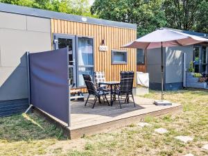 a deck with a table and chairs and an umbrella at Holiday Home Tiny Haus Lene by Interhome in Wemding