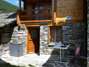 a building with a wooden door and a table outside at Holiday Home Rustico Nurell by Interhome in Madra