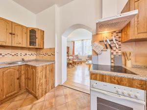 a kitchen with wooden cabinets and a dining room at Apartment Riedlovka 2 by Interhome in Polubný
