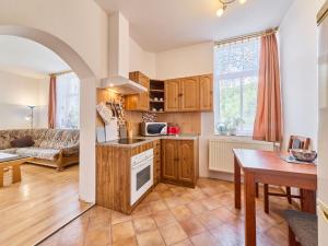 a kitchen and living room with a couch and a table at Apartment Riedlovka 2 by Interhome in Polubný