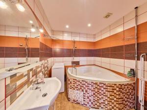 a bathroom with a tub and a sink at Apartment Riedlovka 2 by Interhome in Polubný