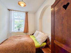 a small bedroom with a bed and a window at Apartment Riedlovka 2 by Interhome in Polubný