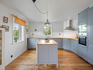a kitchen with blue cabinets and a white island at Holiday Home Teåker by Interhome in Bäckefors