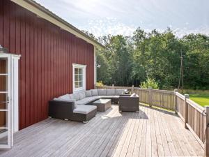 a patio with a couch and chairs on a deck at Holiday Home Teåker by Interhome in Bäckefors