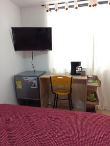 a bedroom with a desk and a television and a chair at Aparta estudio en Álamos in Pasto