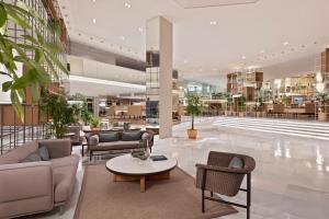 a lobby with couches and tables in a building at Meliá Palma Marina in Palma de Mallorca