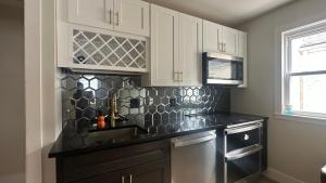 a kitchen with white cabinets and a sink at Comfortable Private Room Shared Bathroom in Vinita Park +5 photos