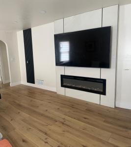 a living room with a flat screen tv on a wall at Comfortable Private Room Shared Bathroom in Vinita Park