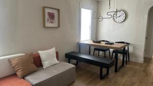 a living room with a couch and a table and a clock at Comfortable Private Room Shared Bathroom in Vinita Park