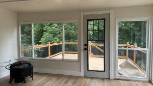 an empty room with two windows and a balcony at Comfortable Private Room Shared Bathroom in Vinita Park