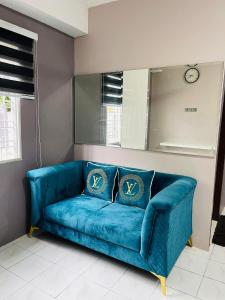 a blue couch in a living room with a mirror at Homestay Permai Inn in Temerloh +7 photos