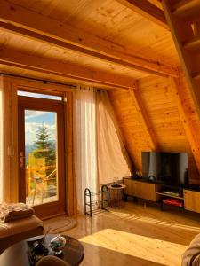 a living room with a large window and a television at Komovi Luxury Sunset in Andrijevica