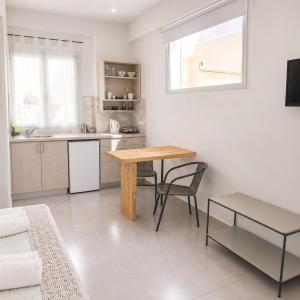 a living room with a table and a kitchen at Christina Boutique Studios Elounda in Elounda