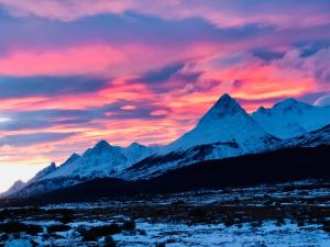 a sunset over a mountain range with snowy mountains at Las Margaritas in Ushuaia
