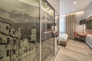 a hotel room with a painting on the wall at Hotel Neue Post I self check-in in Innsbruck