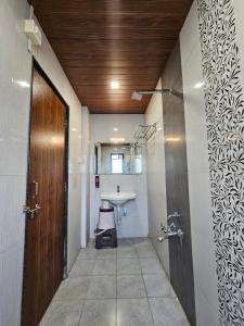 a hallway with a bathroom with a sink and a door at Hotel Royal Residency Executive in Miraj