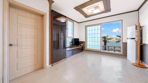 an empty room with a door and a view of the ocean at Geoje Youngsu Pension in Geoje