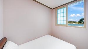 a bedroom with a bed and a window at Geoje Youngsu Pension in Geoje