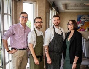 a group of three men and a woman posing for a picture at Hotel Haus Rödgen in Wilnsdorf