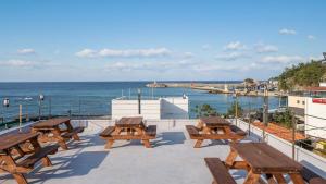 a group of picnic tables on a patio overlooking the ocean at Samcheok jangho sanho Pension in Samcheok