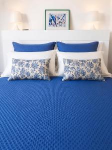 a bed with blue and white pillows on it at Rifugio Caretta in Montecorice