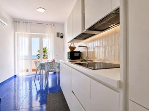 a kitchen with white cabinets and a blue floor at Rifugio Caretta in Montecorice
